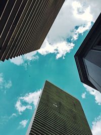 Low angle view of office building against cloudy sky