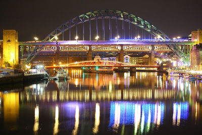 Illuminated bridge over river at night