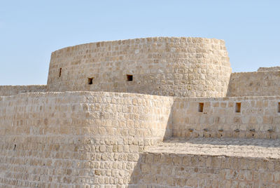 Low angle view of stone wall against sky