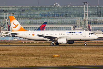 Airplane on airport runway against sky