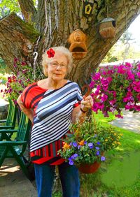 Full length of woman standing on pink flowering plants
