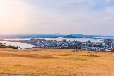 Scenic view of sea and cityscape against sky