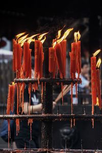 Close-up of lit candles on temple against building