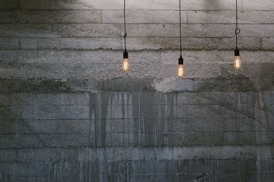 Illuminated light bulbs hanging on wall