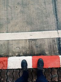 Low section of person standing on wooden floor