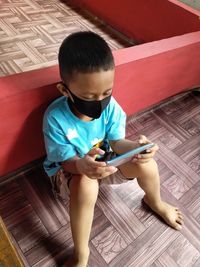 High angle view of boy using mobile phone