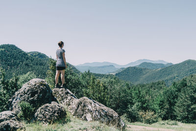 Girl walking along a small path in the mountain of spain. on a sunny summer day