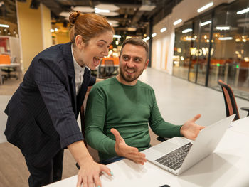 Young man using laptop while sitting on table