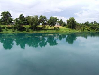 Reflection of trees in water against sky