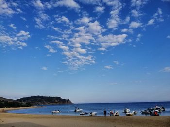People on beach against blue sky