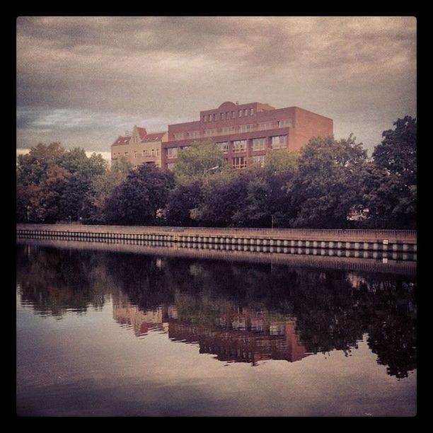 architecture, built structure, transfer print, building exterior, water, tree, auto post production filter, sky, waterfront, river, cloud - sky, reflection, city, connection, bridge - man made structure, residential building, residential structure, cloudy, cloud, bridge