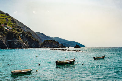 Boats moored on sea against sky