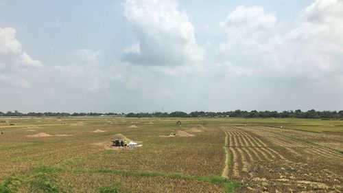 Scenic view of grassy field against cloudy sky