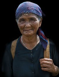 Portrait of senior woman against black background