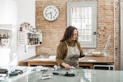 Female artist inspecting a plate and preparing it for a handmade