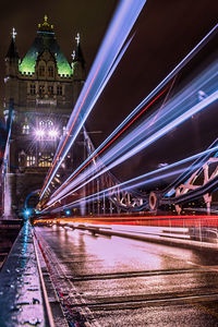 Light trails on bridge in city at night