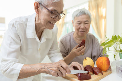 Senior woman slicing fruits