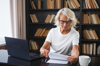 Portrait of woman using digital tablet in library