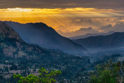 Scenic view of mountains against orange sky