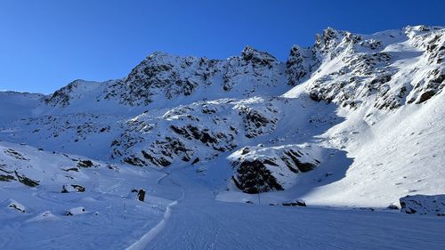Scenic view of snowcapped mountains against clear blue sky