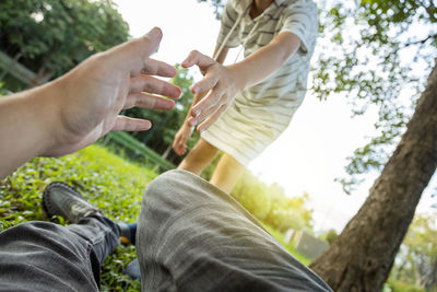 Low section of man and people against trees