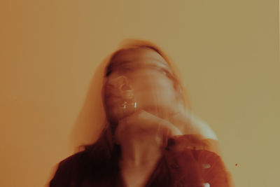 Double exposure of young woman against wall