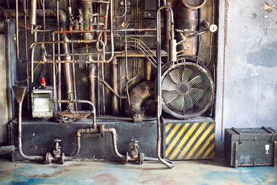 Wall with iron golden trumpets of communication and a large fan at the factory