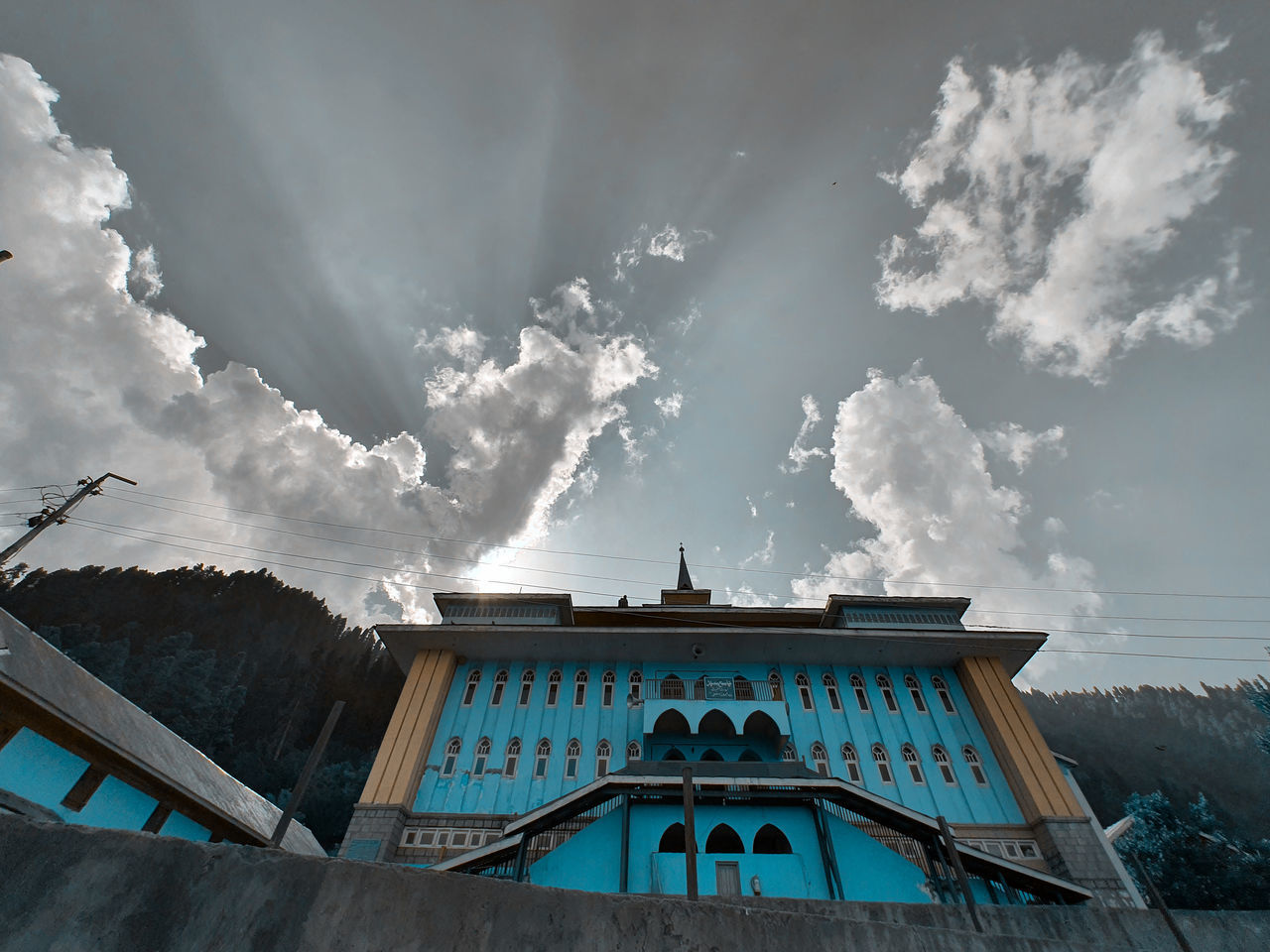 LOW ANGLE VIEW OF CHURCH AMIDST BUILDING AGAINST SKY