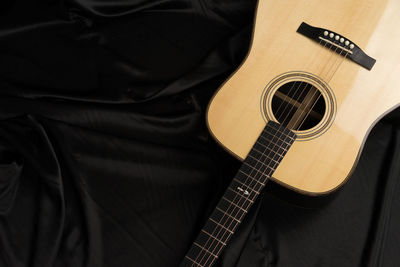 High angle view of guitar on bed