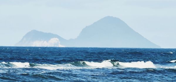 Scenic view of sea and mountains against sky