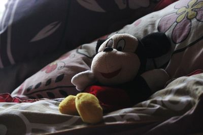 Close-up of toy sleeping on bed