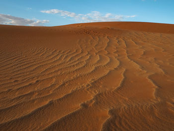 Sand dunes in desert against sky