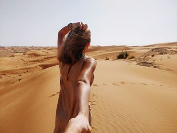 Rear view of woman on sand dune