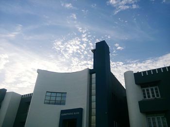 Low angle view of buildings against cloudy sky