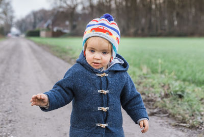 Cute girl standing on footpath