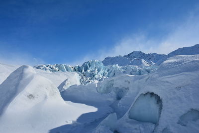 Scenic view of a glacier against a blue sky