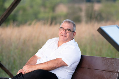 Portrait of man using laptop while sitting on field