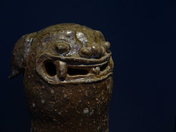 Close-up of statue against black background