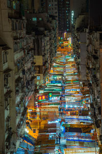 High angle view of illuminated street amidst buildings at night