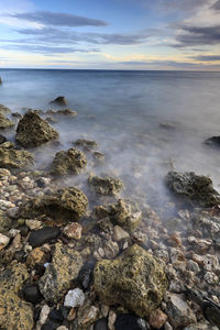 Scenic view of rocks at beach against sky