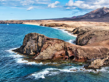 Aerial view of rocky coastline against sky