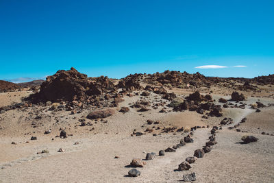 Scenic view of desert against clear blue sky