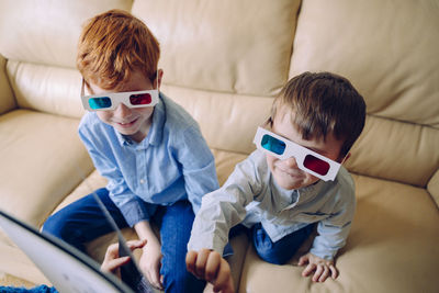 Boys sitting on sofa at home