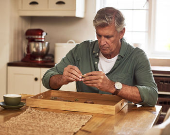 Senior man smoking weed at home. mature guy with medical marijuana. cbd medicine and natural health