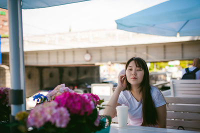 Portrait of woman having drink while sitting in restaurant