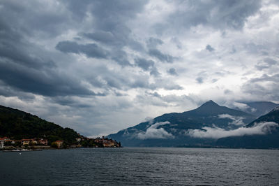 Scenic view of sea by mountains against sky