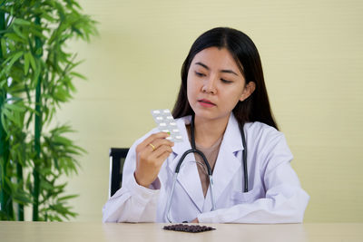 Portrait of a beautiful young woman sitting on table