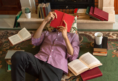 Midsection of man reading book while sitting on table