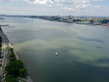 High angle view of cityscape by sea against sky