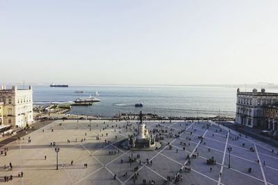 High angle view of sea by buildings against clear sky